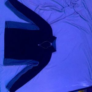 A sweater with a zip on the front colors one black and gray other blue and gray